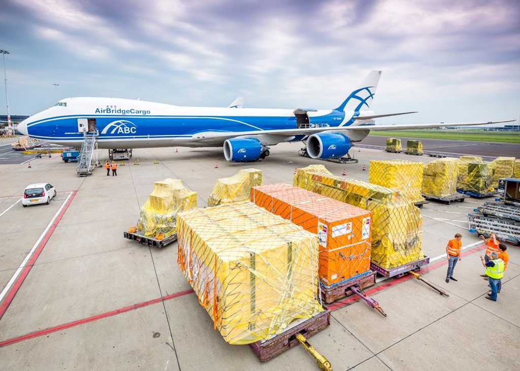Avión en un hub logístico multimodal en México con contenedores de carga